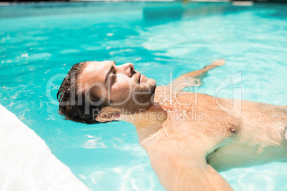 Peaceful man floating in the pool