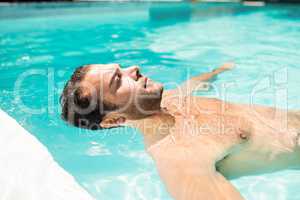 Peaceful man floating in the pool