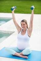 Pregnant woman lifting dumbbells
