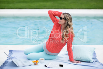 Pregnant woman relaxing outside and using laptop