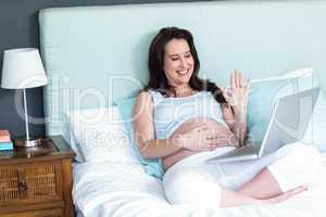 Pregnant woman using laptop