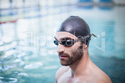 Focused man wearing swim cap and goggles