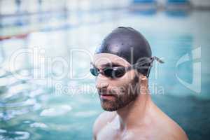 Focused man wearing swim cap and goggles