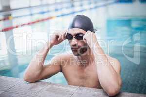 Focused man wearing swim cap and goggles