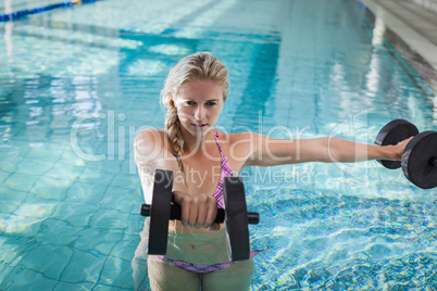 Attractive woman lifting dumbbells