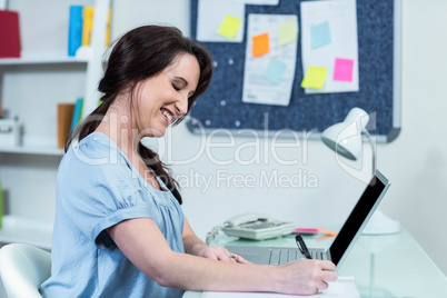 Pregnant woman taking notes