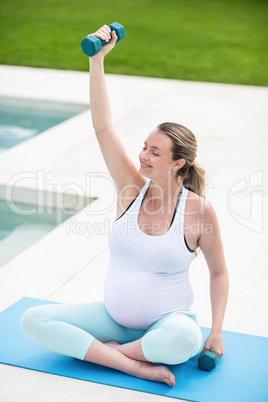 Pregnant woman lifting dumbbells