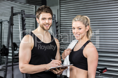 Smiling fit couple taking notes