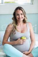 Pregnant woman holding an apple