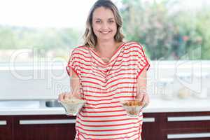Pregnant woman showing bowls of cereals