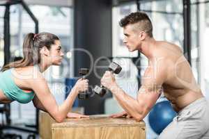 Fit couple lifting dumbbells