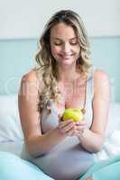 Pregnant woman holding an apple