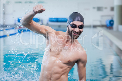 Smiling man triumphing with raised arm