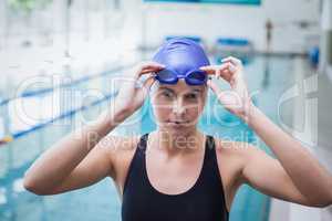 Pretty woman wearing swim cap and goggles