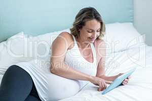 Pregnant woman using tablet computer