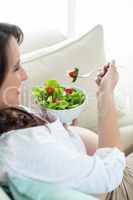 Pregnant woman eating salad