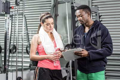 Trainer and woman looking at workout plan