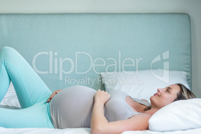 Pregnant woman lying on her bed