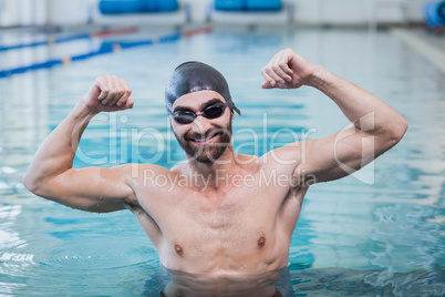 Smiling man triumphing with raised arms