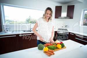 Pregnant woman cutting vegetables