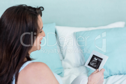 Pregnant woman looking at ultrasound scans