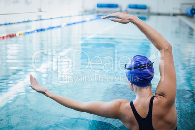 Fit woman stretching her arms in the water