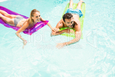 Happy couple with lilos in the pool