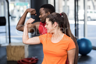 Smiling woman and man contracting biceps
