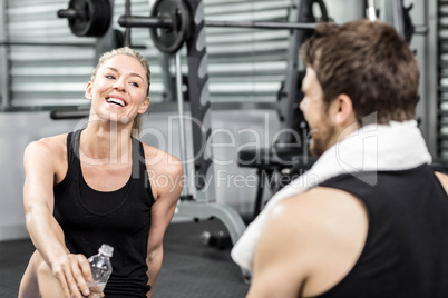 Smiling fit couple sitting