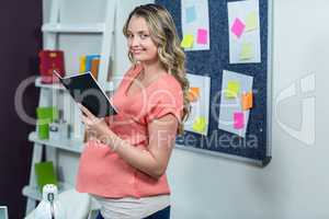 Pregnant woman reading a notebook