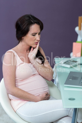 Worried pregnant woman at desk