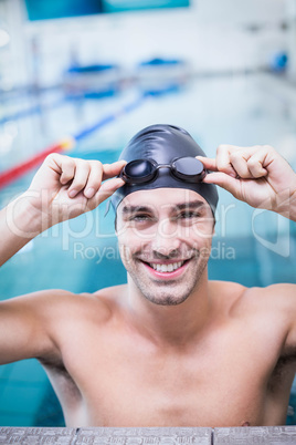 Handsome man wearing swim cap and goggles