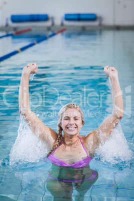 Pretty woman triumphing with raised arms