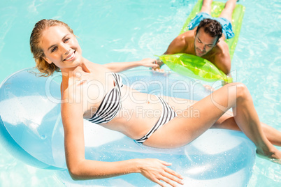 Happy couple with lilos in the pool