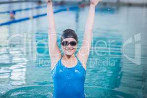 Fit woman triumphing with raised arms