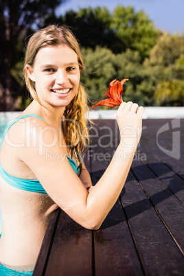 Smiling blonde holding red flower