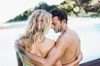Rear view of couple sitting by the pool