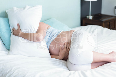 Pregnant woman lying on bed