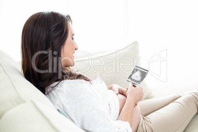 Pregnant woman looking at ultrasound scans