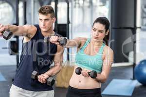 Fit people lifting dumbbells