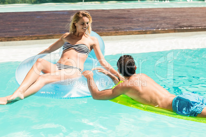 Happy couple with lilos in the pool