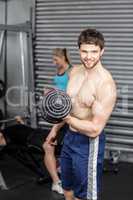 Shirtless man lifting dumbbells