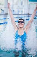 Fit woman triumphing with raised arms