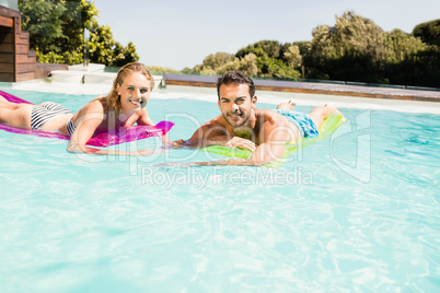 Happy couple with lilos in the pool