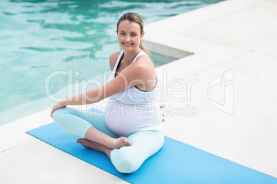 Pregnant woman stretching on mat