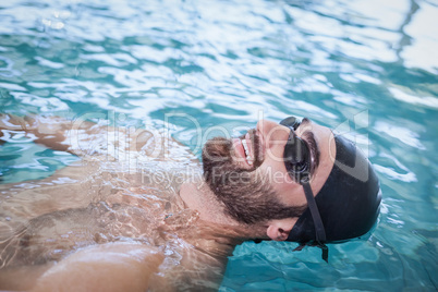 Fit man swimming on the back