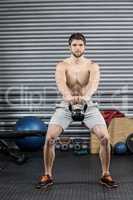 Shirtless man lifting dumbbells