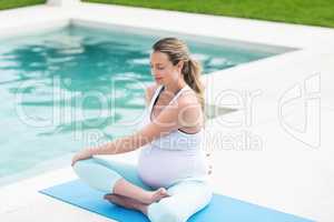 Pregnant woman stretching on mat