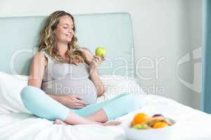 Pregnant woman holding an apple