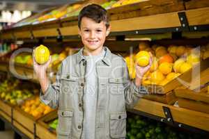 Cute boy holding lemons